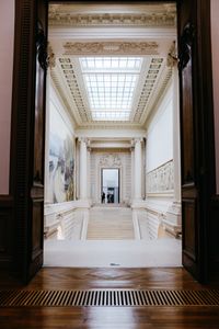 A stunning view through an archway showcasing a grand staircase in a French art museum.
