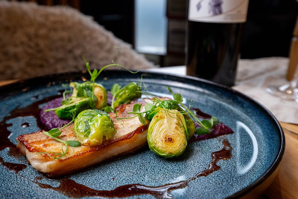 Delicious pork belly with Brussels sprouts and sauce, served in Bratislava, Slovakia.