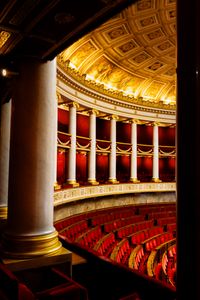 Ornate theater interior with red seats and golden details, capturing classic architectural grandeur.