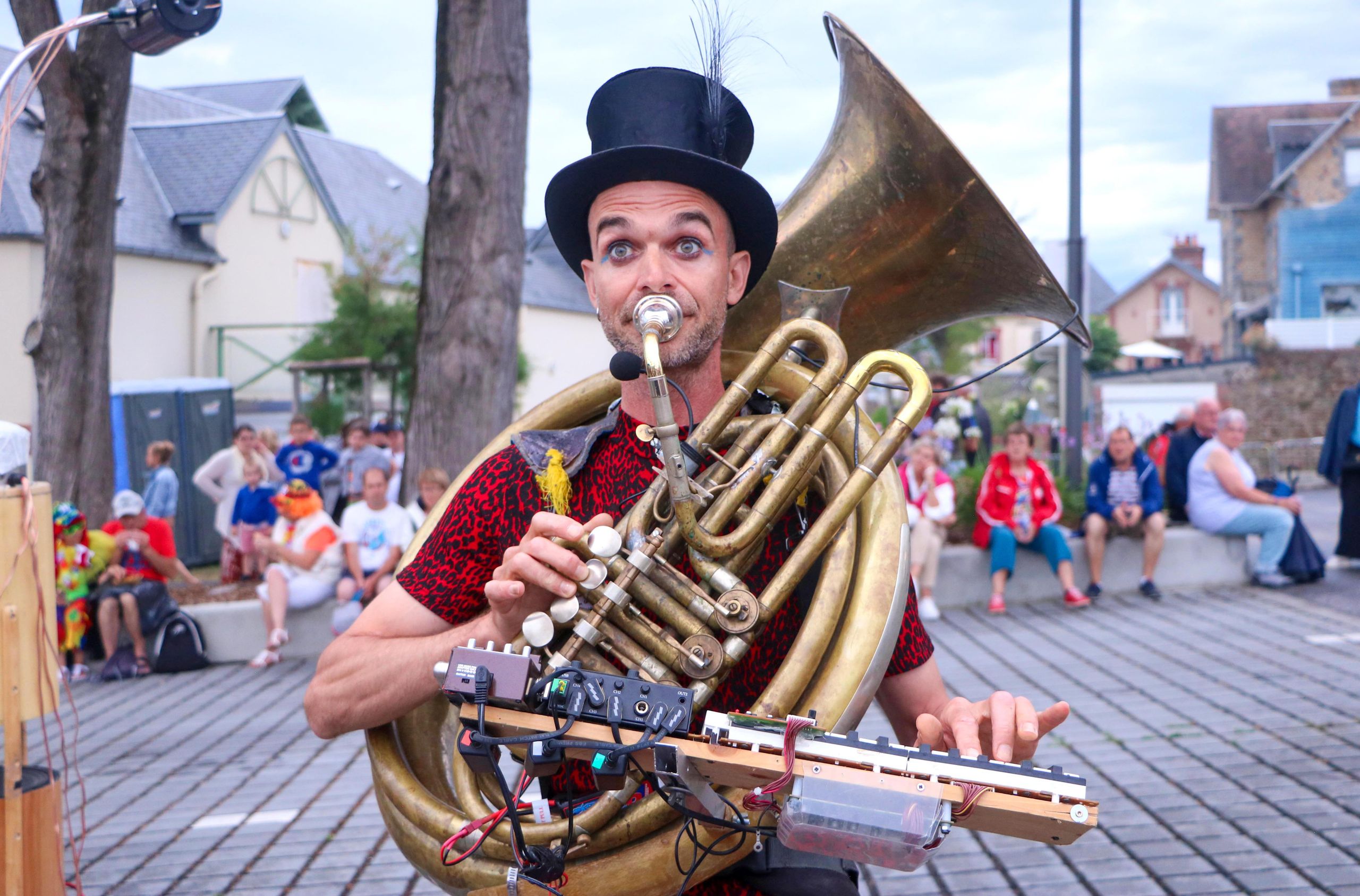 Street performer with a sousaphone entertaining in a lively outdoor setting in Saint-Pair-sur-Mer, Normandie, France.