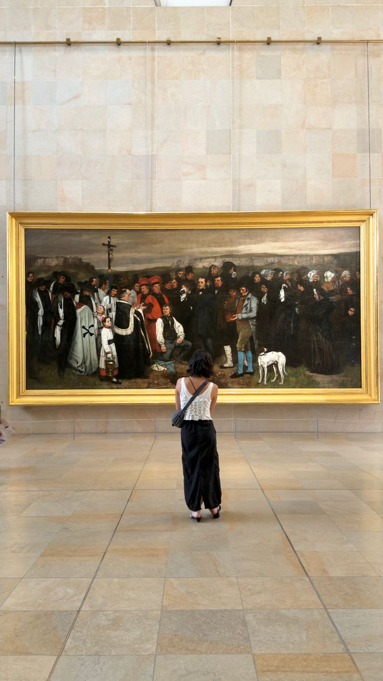 A visitor admires Gustave Courbet's 'A Burial at Ornans' at the Musée d'Orsay in Paris.