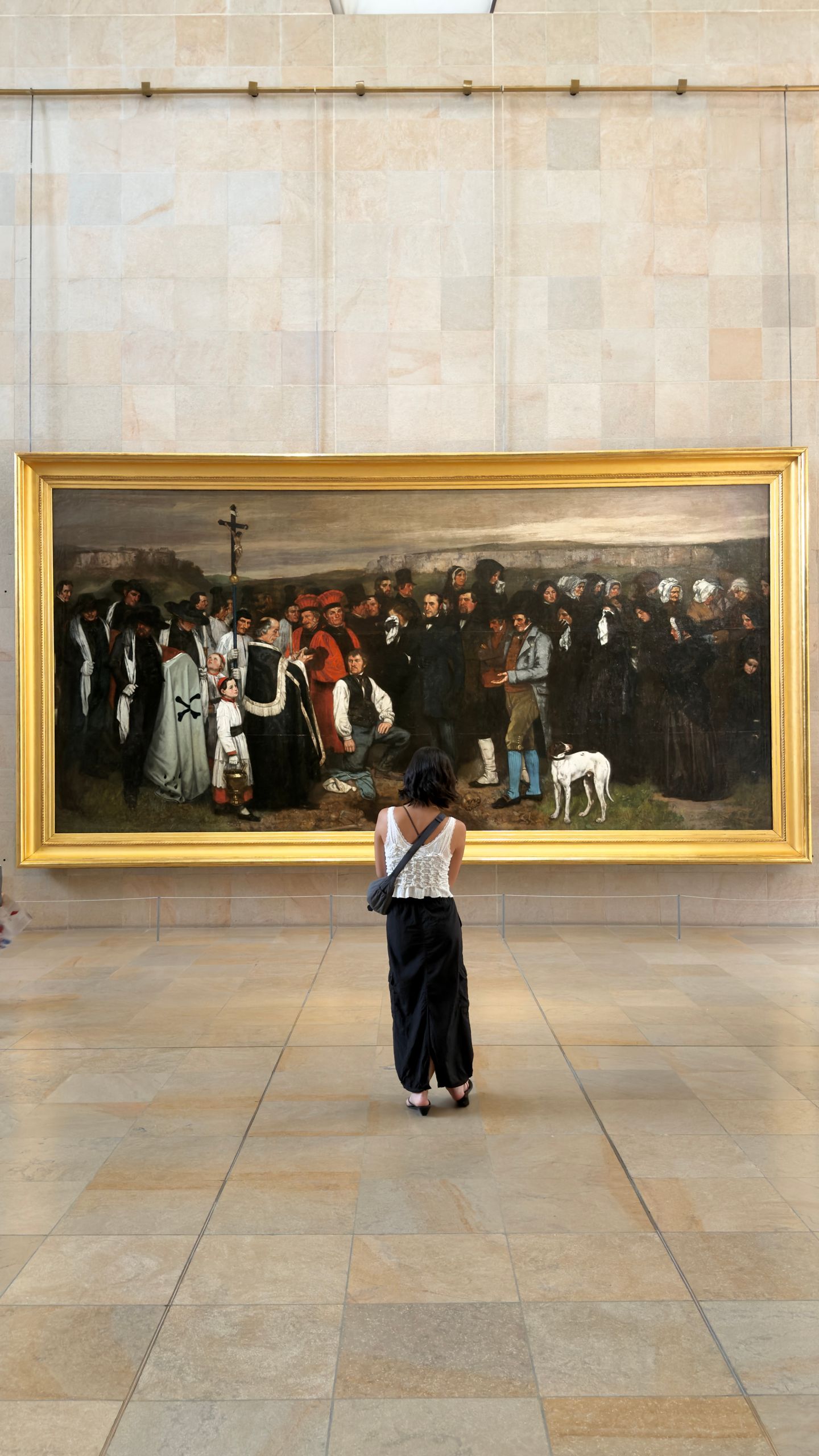 A visitor admires Gustave Courbet's 'A Burial at Ornans' at the Musée d'Orsay in Paris.