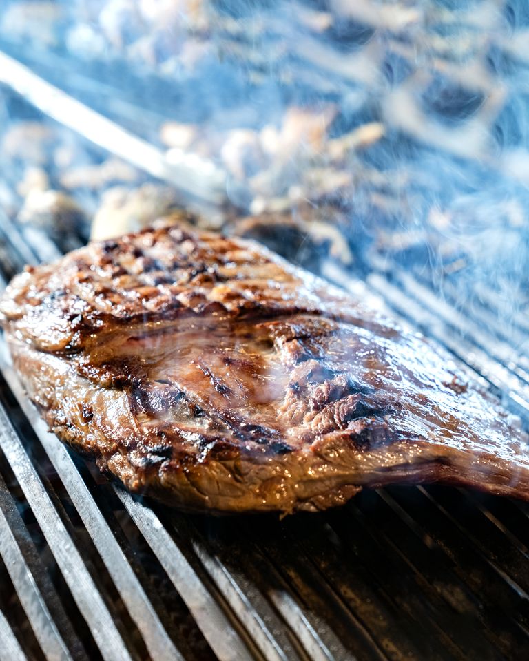 Close-up of a perfectly grilled steak on a barbecue, capturing the smoky and juicy texture.