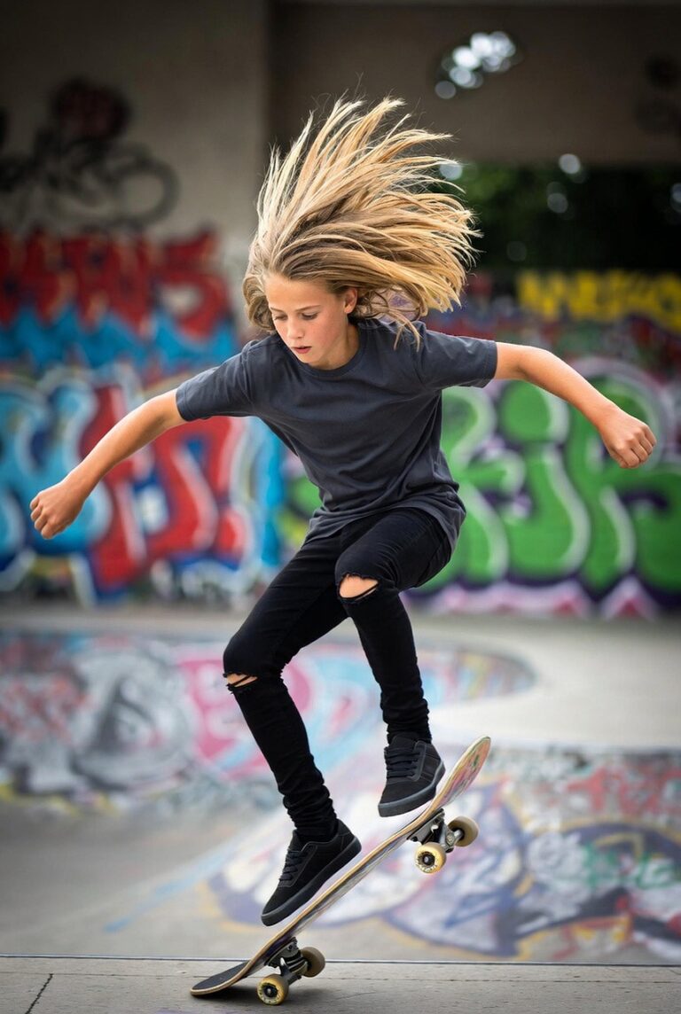 skateboarding, skateboard trick, teen skateboarder, extreme sports, balance and coordination, graffiti wall, urban culture, outdoor recreation, creative expression, adolescent athlete, long hair, youth sports, action photography, youthful, city sport, teen boy, alternative lifestyle, youth fashion, motion and movement, skateboard lifestyle