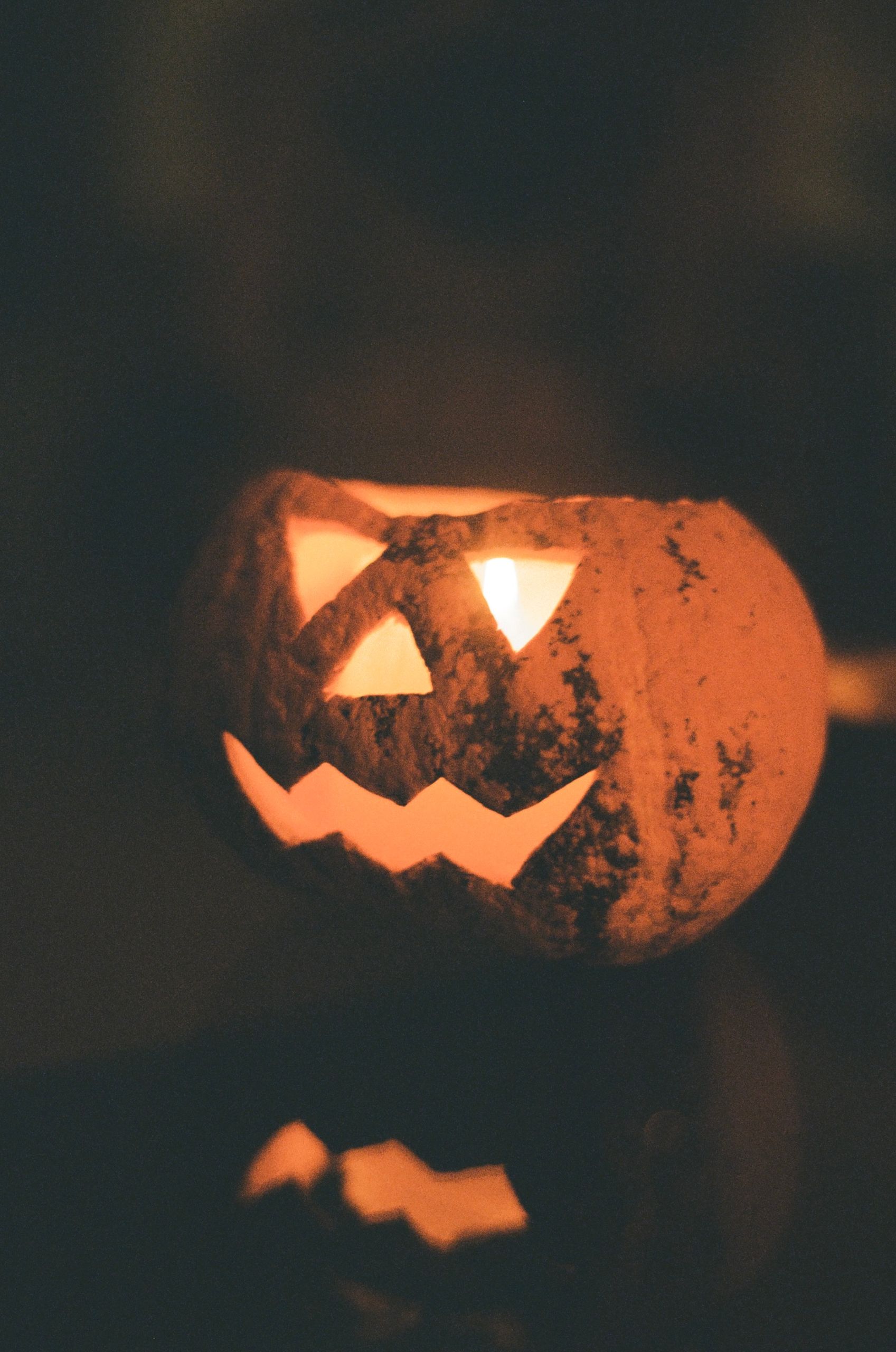 Spooky carved pumpkin with candlelight, perfect for Halloween decor.